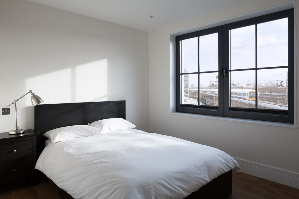ロンドンにある広い北欧スタイルのおしゃれな客用寝室 (白い壁)