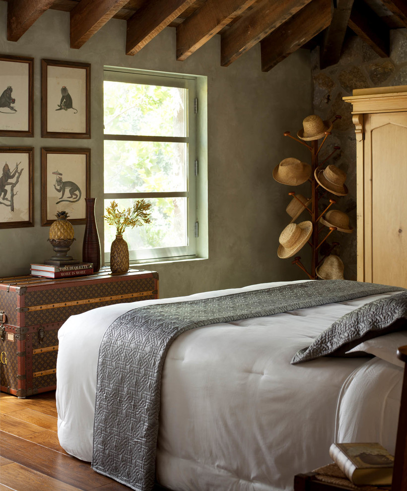 Foto di una camera da letto stile rurale con pareti grigie, pavimento in legno massello medio e pavimento marrone
