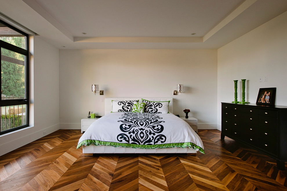 This is an example of a contemporary bedroom in Vancouver with white walls, medium hardwood flooring and brown floors.