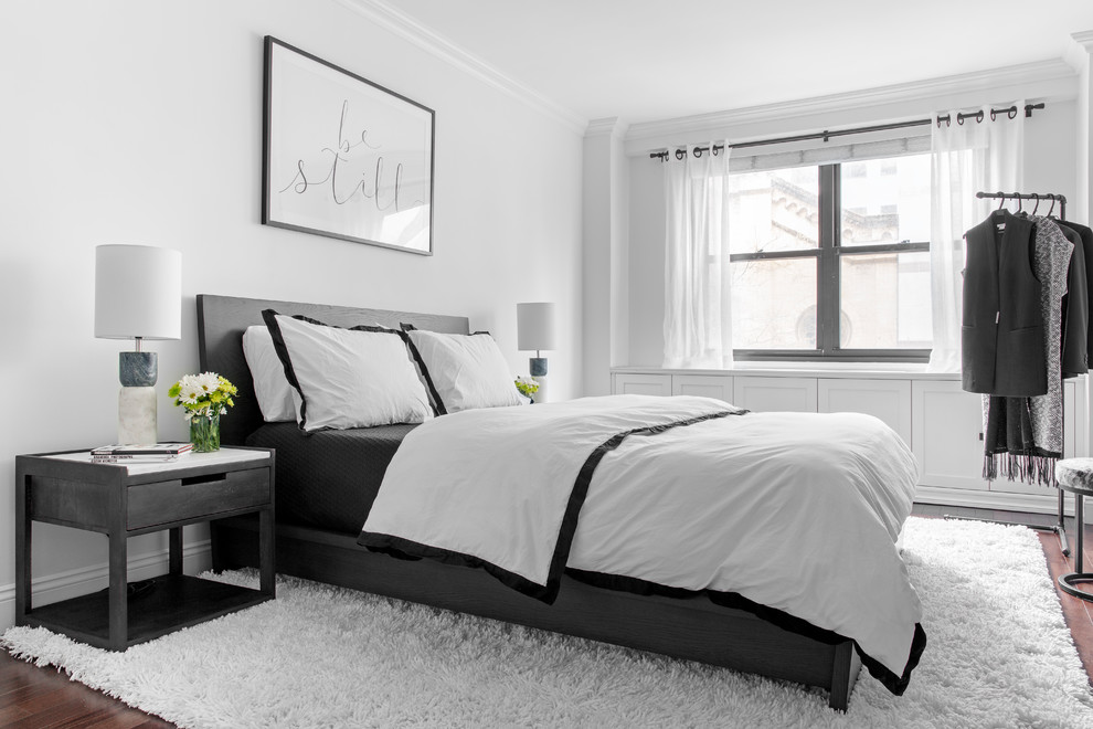 Kleines Modernes Hauptschlafzimmer mit weißer Wandfarbe, dunklem Holzboden und braunem Boden in New York