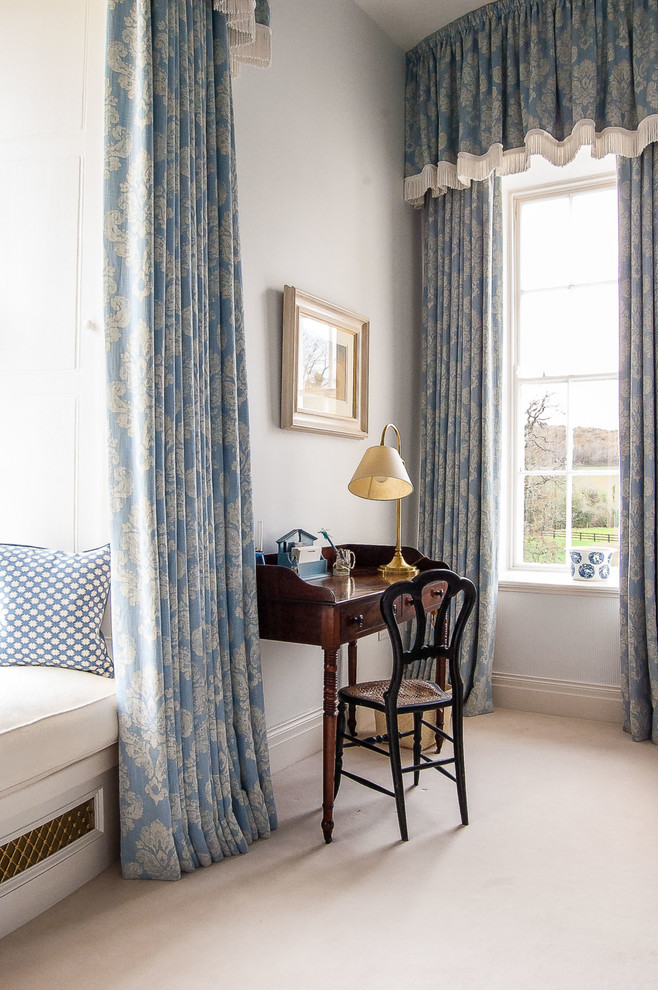 This is an example of a small traditional bedroom in London with blue walls and carpet.