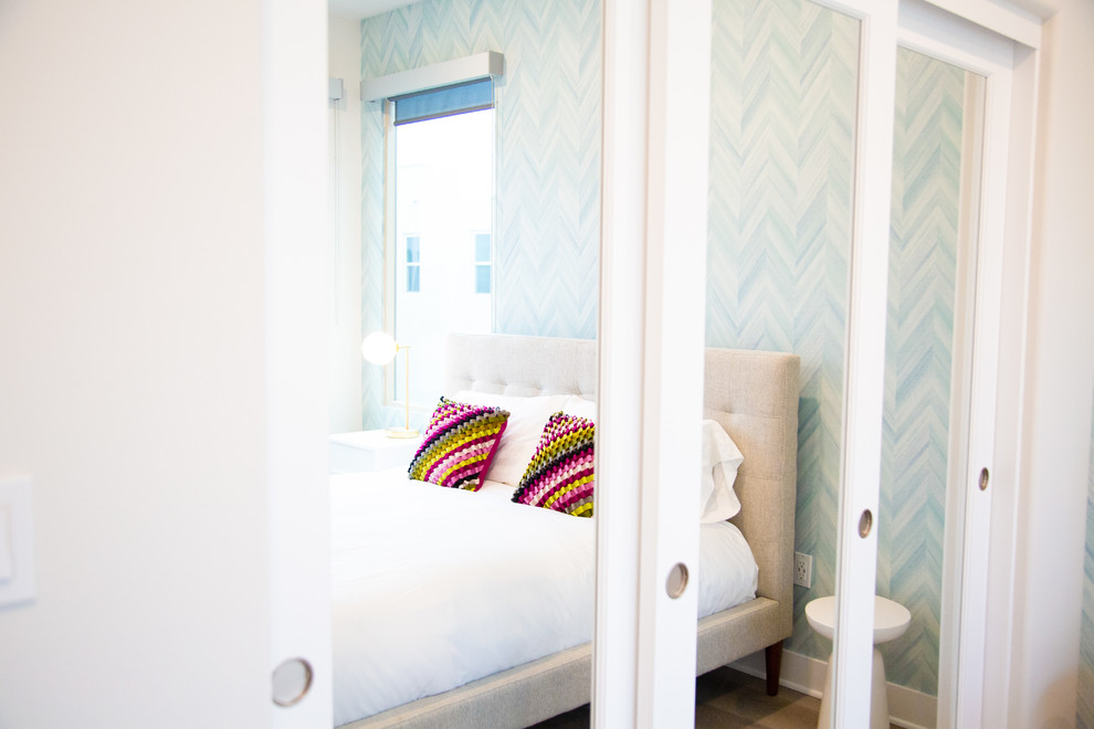 Modelo de habitación de invitados actual de tamaño medio con paredes blancas, suelo de madera en tonos medios y suelo gris