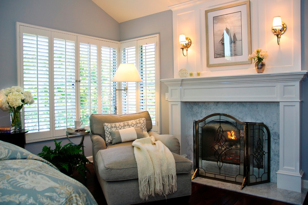 オレンジカウンティにある中くらいなトランジショナルスタイルのおしゃれな主寝室 (青い壁、濃色無垢フローリング、茶色い床、標準型暖炉、木材の暖炉まわり、グレーとブラウン) のレイアウト