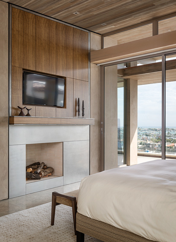 Modernes Hauptschlafzimmer mit beiger Wandfarbe, Kamin und Kaminumrandung aus Metall in Orange County