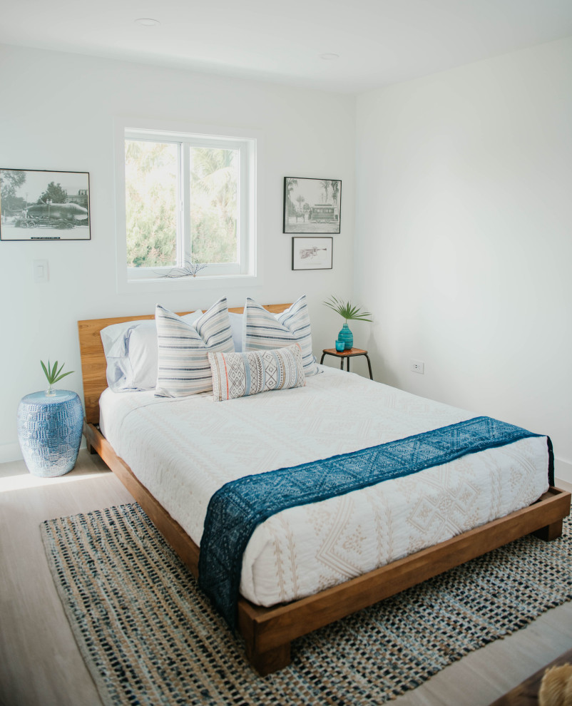 Cette photo montre une petite chambre d'amis bord de mer avec un mur blanc, un sol en carrelage de porcelaine et un sol beige.