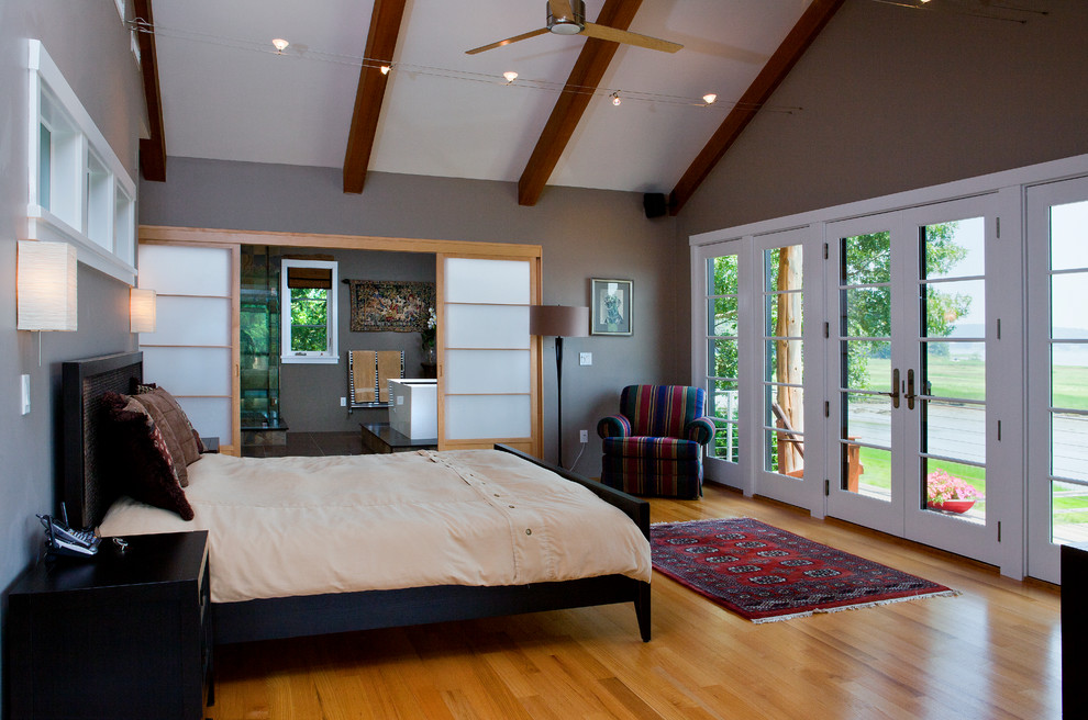 Ejemplo de dormitorio principal asiático con suelo de madera clara