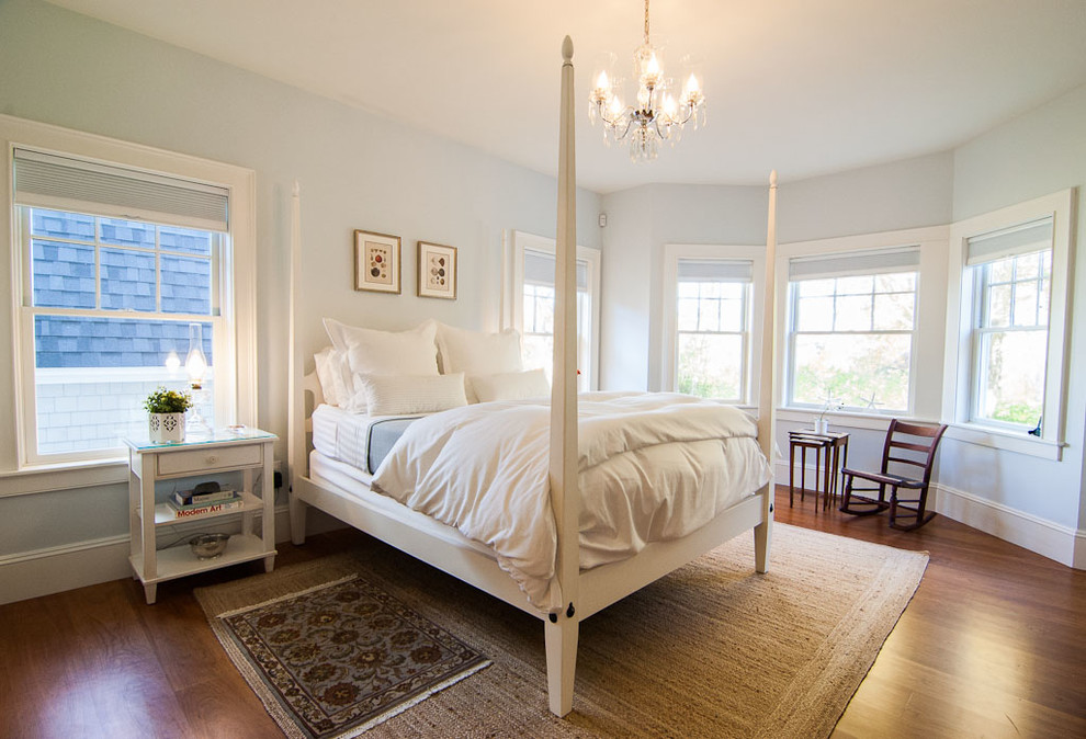Imagen de dormitorio principal tradicional renovado grande con paredes azules, suelo de madera en tonos medios y suelo marrón