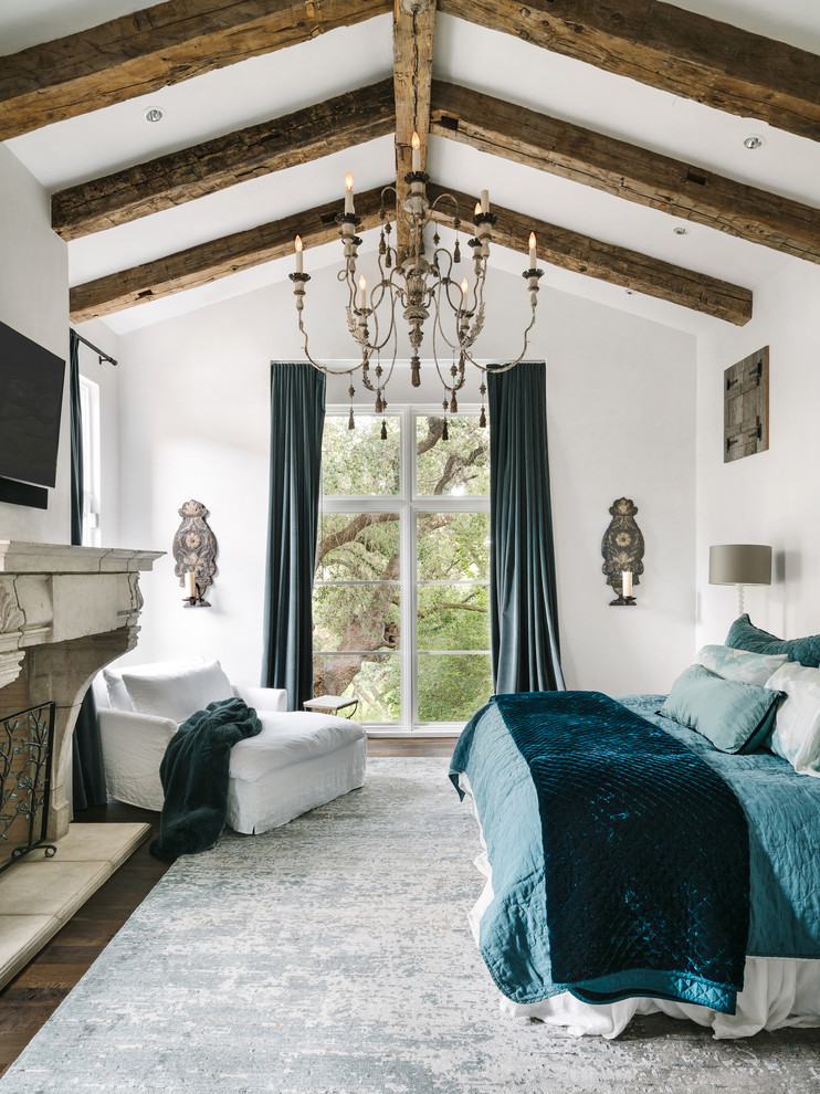 Mediterranes Hauptschlafzimmer mit weißer Wandfarbe, dunklem Holzboden und Kamin in Austin