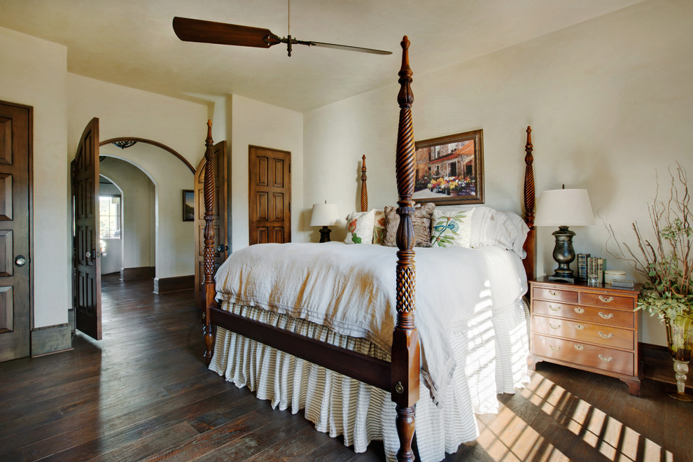 This is an example of a mediterranean guest bedroom in Other with beige walls, dark hardwood flooring and brown floors.
