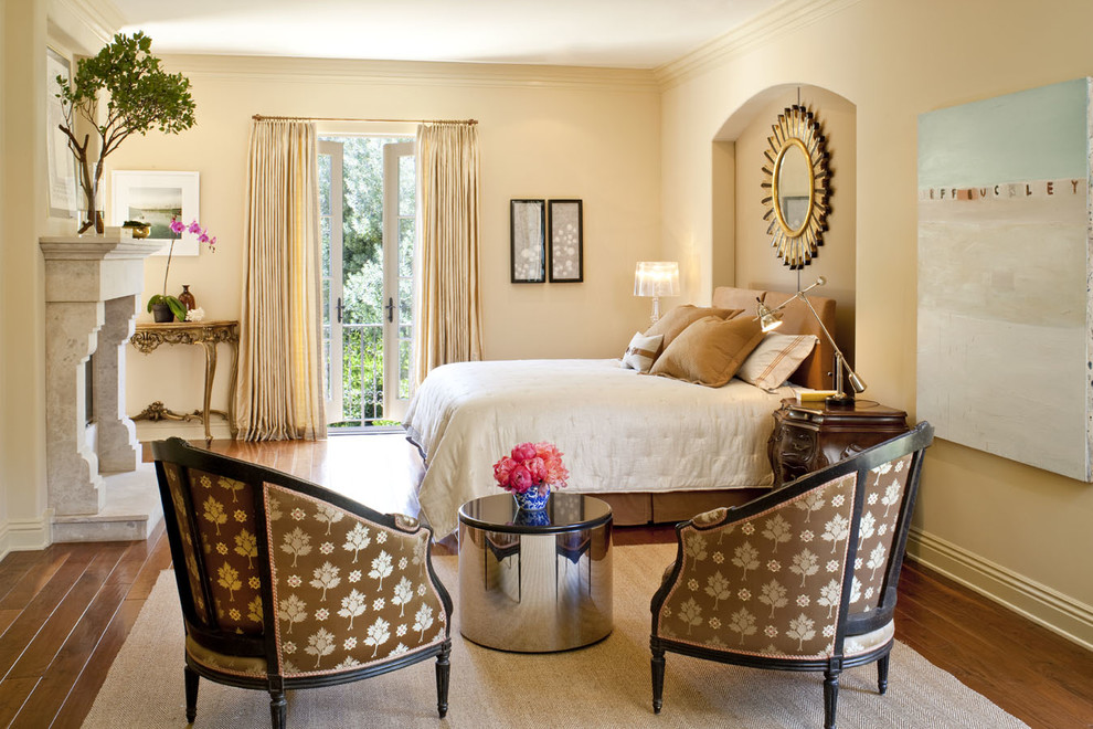 Diseño de dormitorio clásico con paredes beige, suelo de madera en tonos medios y todas las chimeneas