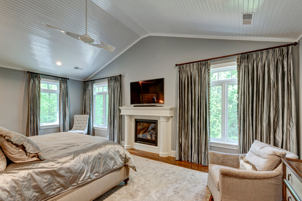 ローリーにある広いトランジショナルスタイルのおしゃれな主寝室 (グレーの壁、濃色無垢フローリング、標準型暖炉、木材の暖炉まわり)