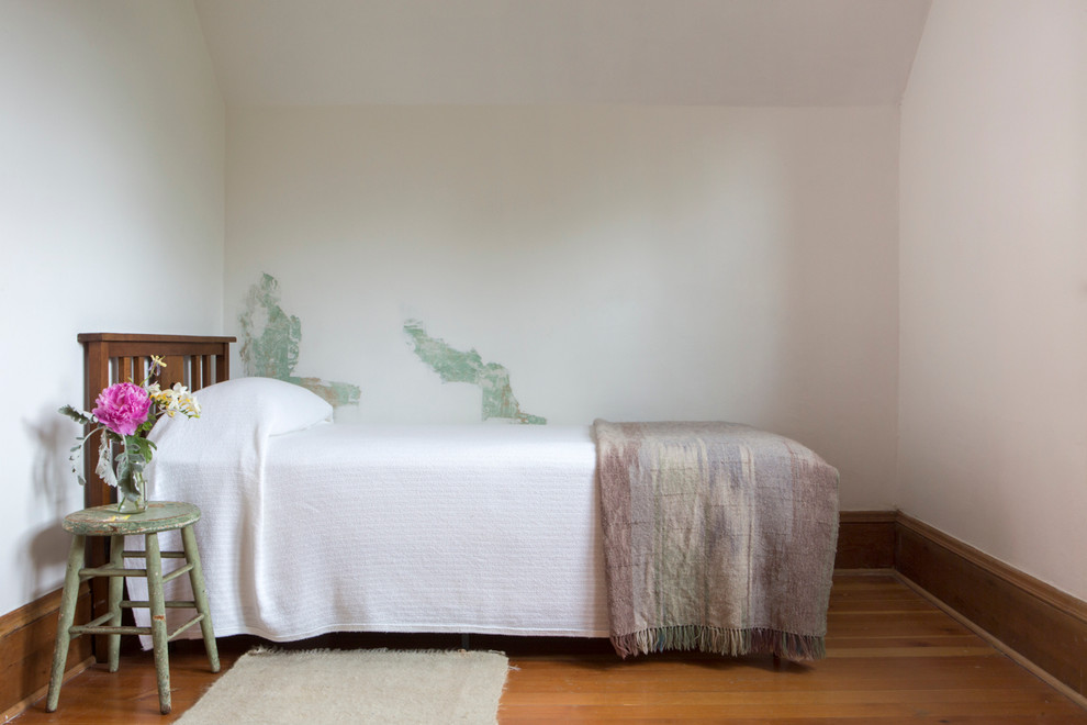 Foto de habitación de invitados de estilo de casa de campo pequeña con paredes blancas y suelo de madera en tonos medios