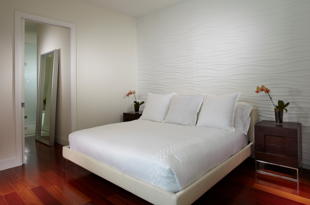 Modelo de dormitorio principal actual de tamaño medio con paredes blancas, suelo de madera en tonos medios y suelo rojo