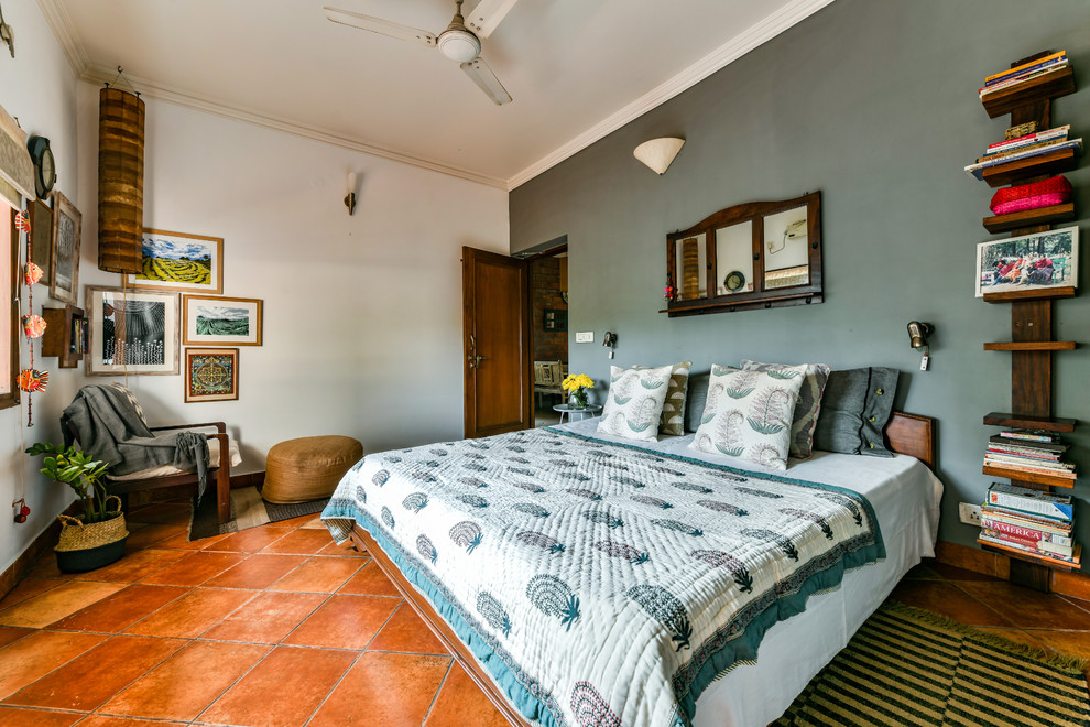 Foto di una camera da letto chic con pareti blu e pavimento marrone