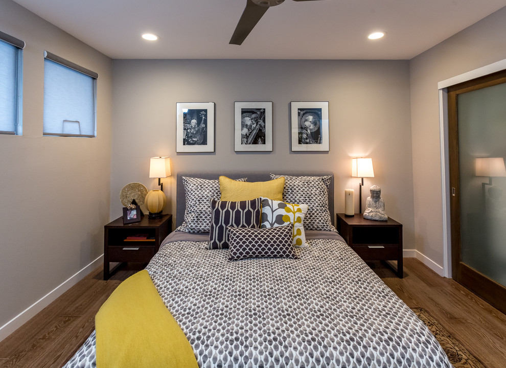 Пример оригинального дизайна: гостевая спальня среднего размера, (комната для гостей) в стиле ретро с серыми стенами и паркетным полом среднего тона без камина