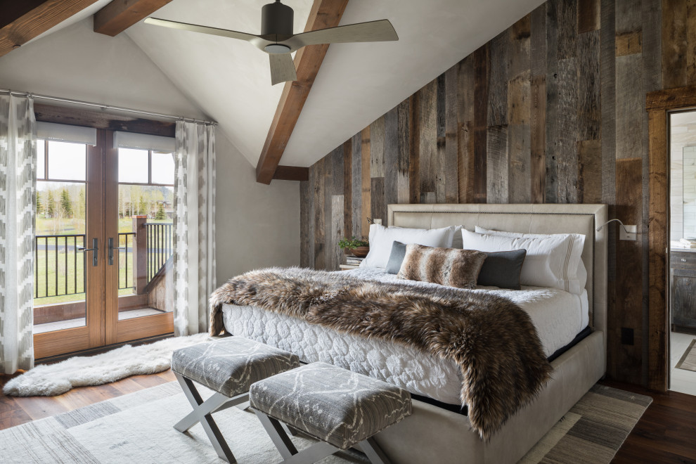 На фото: спальня в стиле рустика с коричневым полом, балками на потолке, деревянными стенами и паркетным полом среднего тона с