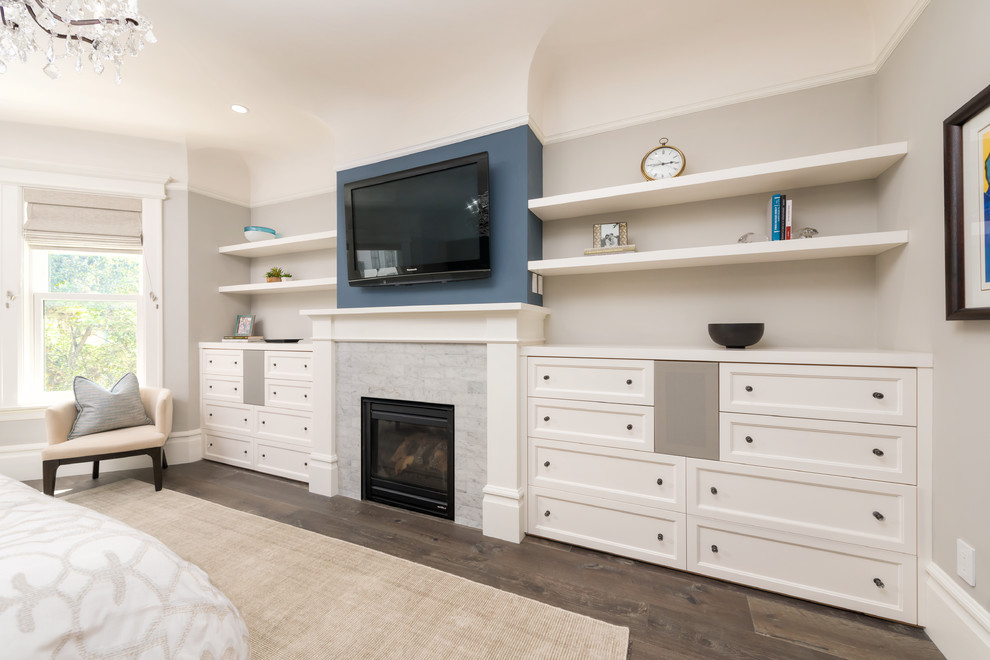 Exemple d'une chambre parentale chic de taille moyenne avec un mur gris, parquet foncé, une cheminée standard, un manteau de cheminée en carrelage et un sol marron.