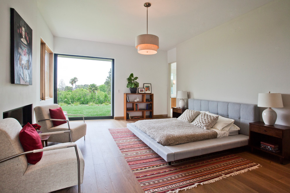 Modernes Schlafzimmer mit weißer Wandfarbe und braunem Holzboden in Los Angeles