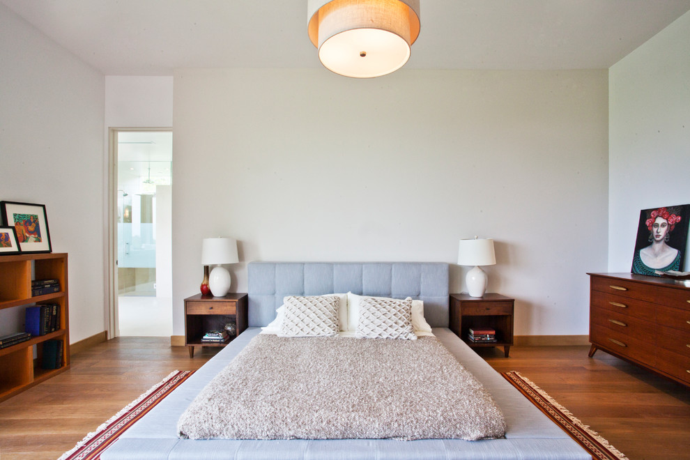 Trendy medium tone wood floor bedroom photo in Los Angeles with white walls