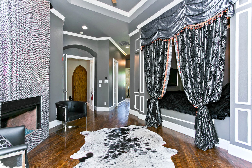 Cette image montre une chambre traditionnelle avec un mur gris, parquet foncé, un manteau de cheminée en carrelage et une cheminée d'angle.