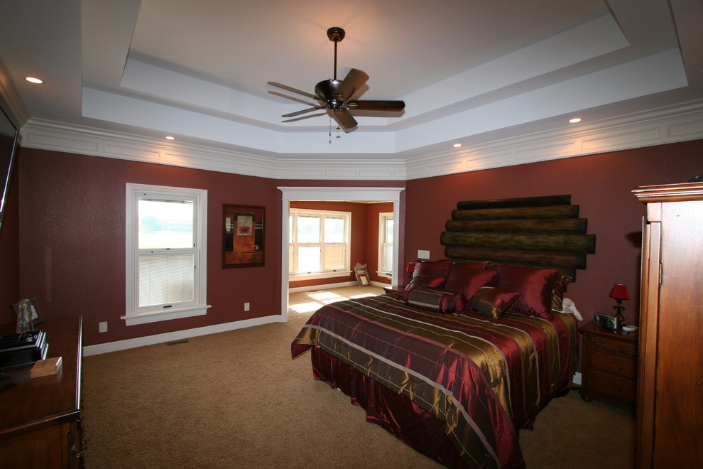 Modelo de dormitorio principal tradicional de tamaño medio con paredes rojas y moqueta