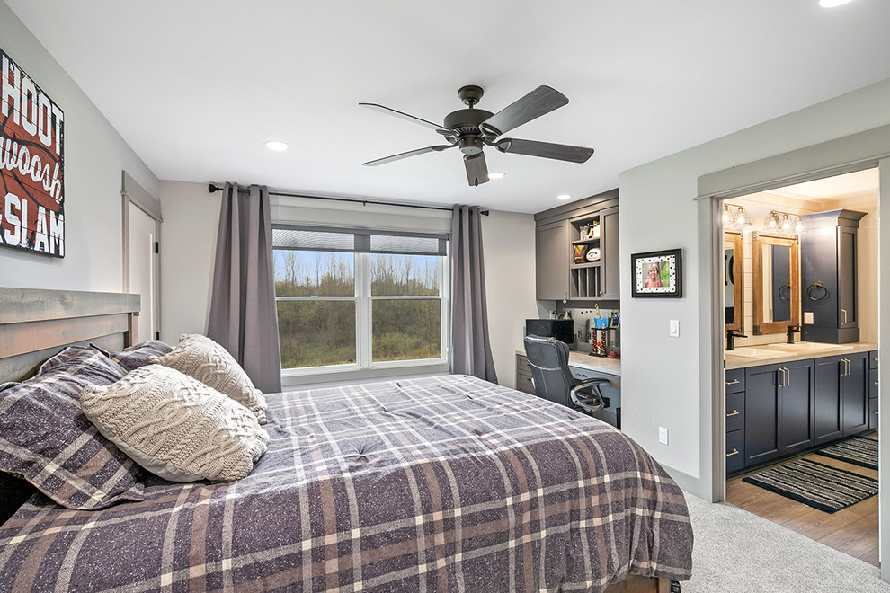 グランドラピッズにあるカントリー風のおしゃれな客用寝室 (グレーの壁、カーペット敷き、ベージュの床) のインテリア