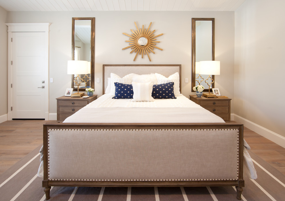 Immagine di una camera da letto tradizionale con pareti beige e pavimento in legno massello medio