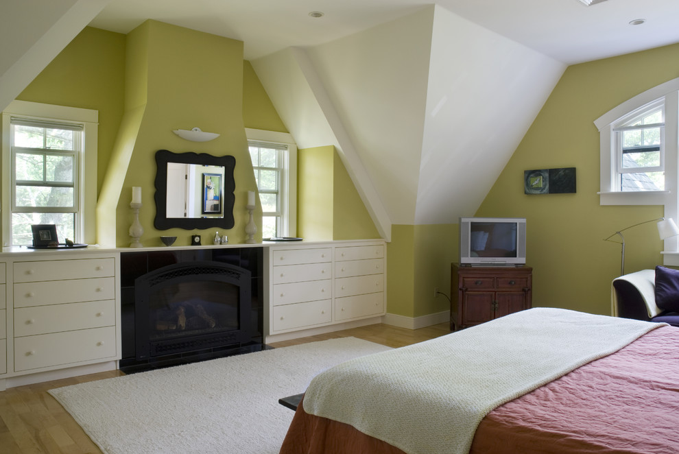 Aménagement d'une grande chambre parentale classique avec un mur vert, parquet clair, une cheminée standard et un manteau de cheminée en pierre.