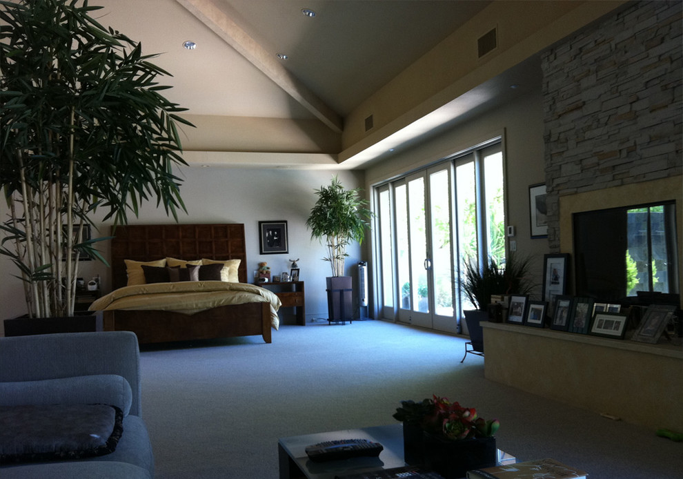 Imagen de dormitorio principal tropical grande sin chimenea con paredes grises, moqueta y suelo gris