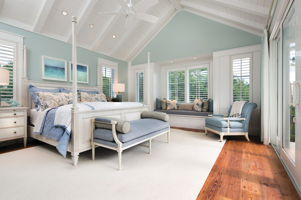 Großes Hauptschlafzimmer ohne Kamin mit blauer Wandfarbe und braunem Holzboden in Miami