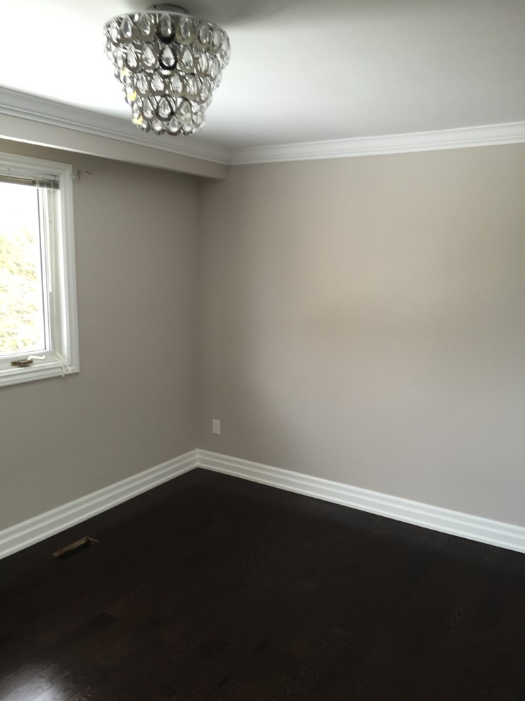 Foto de dormitorio principal actual de tamaño medio con paredes grises, suelo de madera oscura y suelo marrón