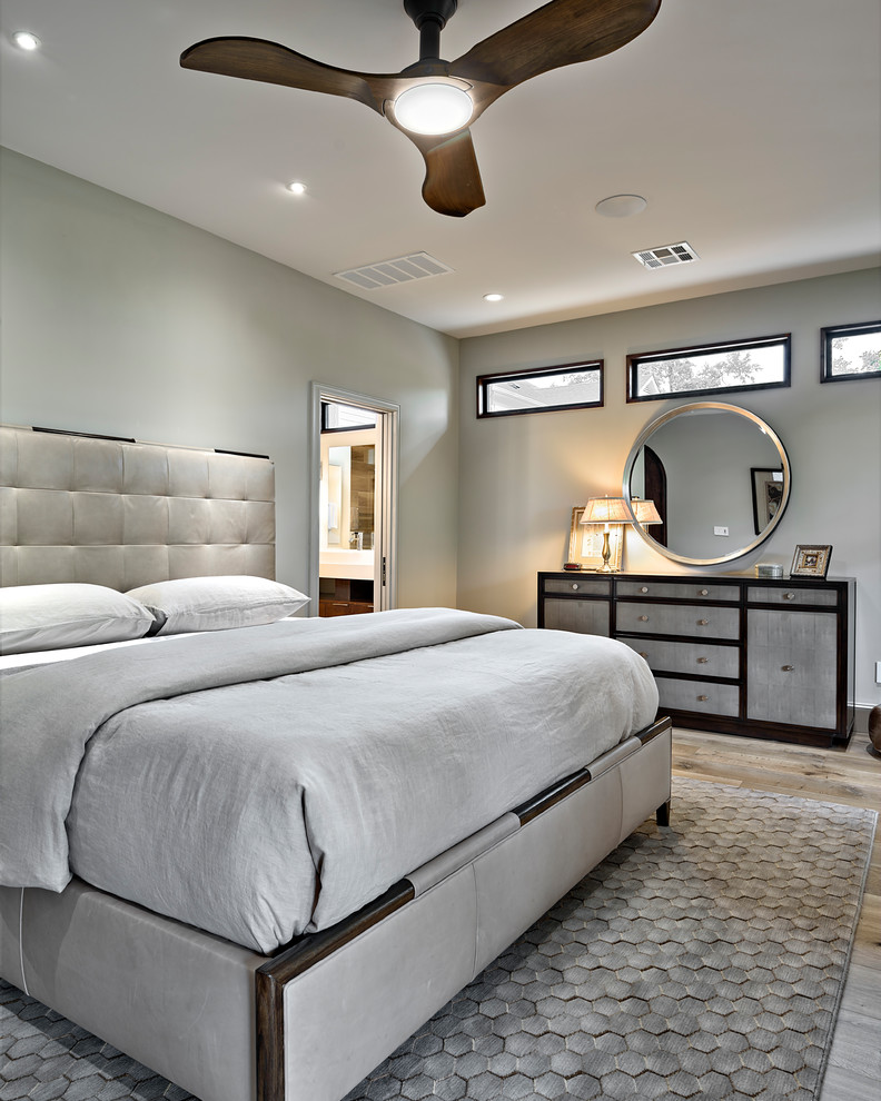 Traditional master bedroom in Austin with beige walls, light hardwood flooring and beige floors.