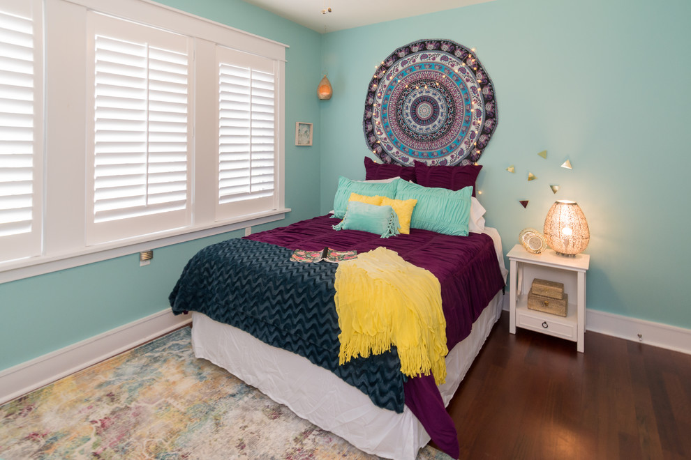 Modelo de dormitorio bohemio de tamaño medio con paredes azules, suelo de madera en tonos medios y suelo marrón