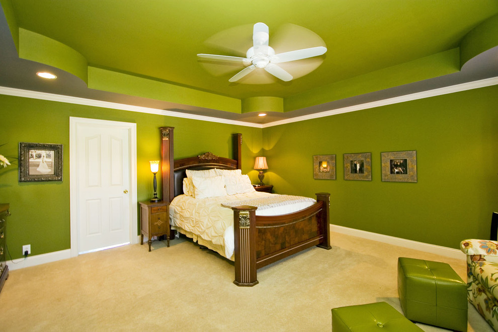 Inredning av ett eklektiskt sovrum, med gröna väggar och heltäckningsmatta