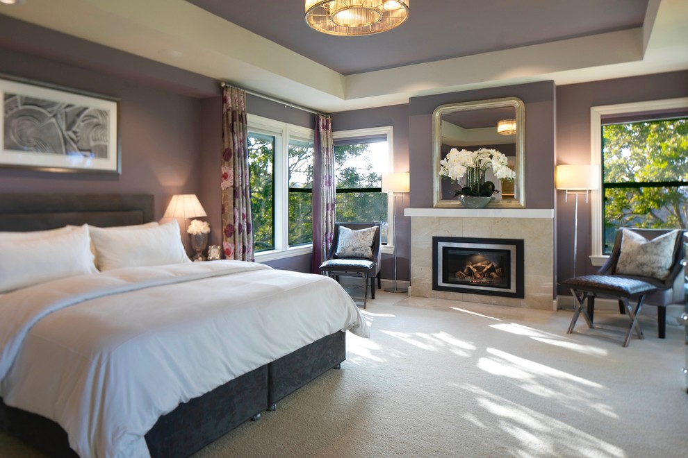 Large contemporary master bedroom in San Francisco with purple walls, carpet, a standard fireplace, a stone fireplace surround and beige floors.