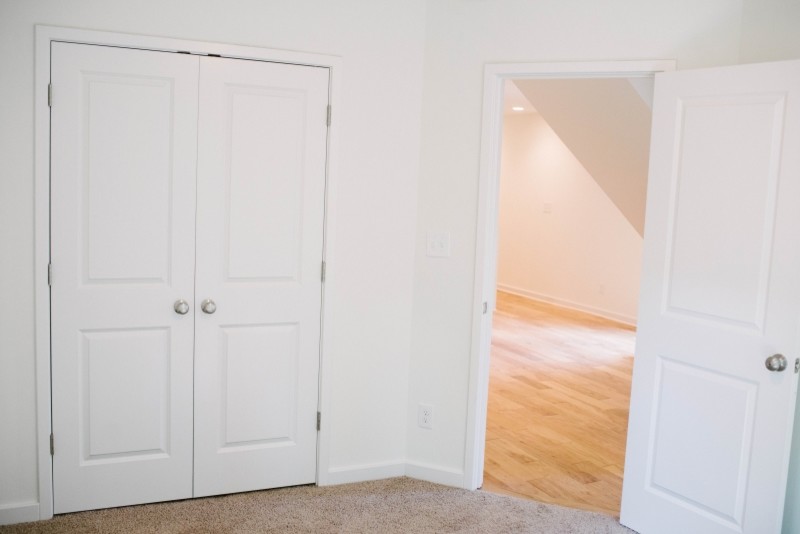 Bild på ett mellanstort minimalistiskt huvudsovrum, med vita väggar och mellanmörkt trägolv