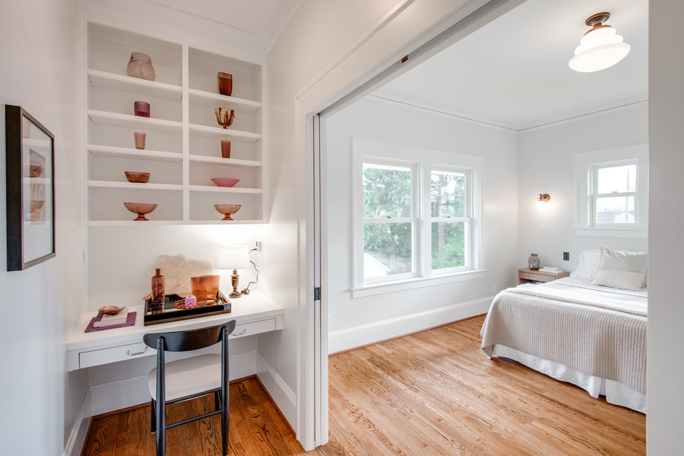 Diseño de dormitorio tradicional renovado con paredes blancas, suelo de madera en tonos medios y con escritorio
