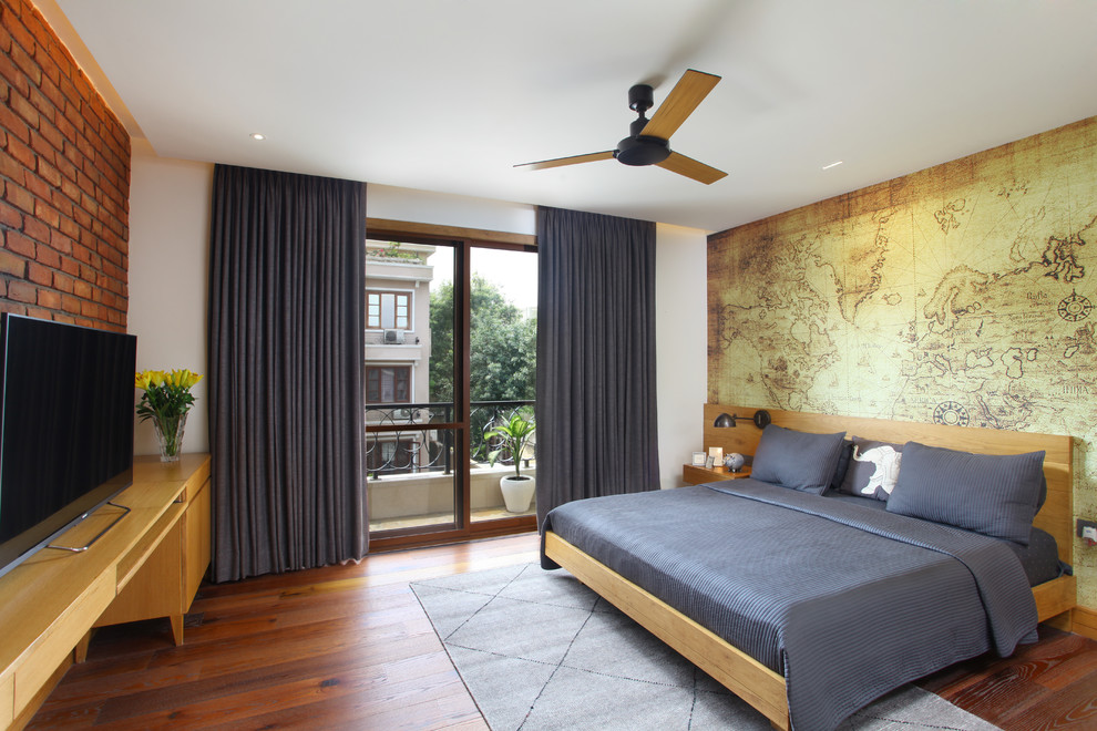 Contemporary grey and brown bedroom in Delhi with white walls, medium hardwood flooring and brown floors.