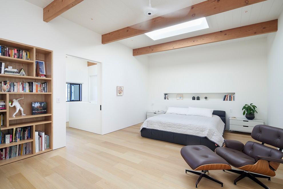 Ispirazione per una camera da letto minimal con pareti bianche, parquet chiaro e pavimento beige