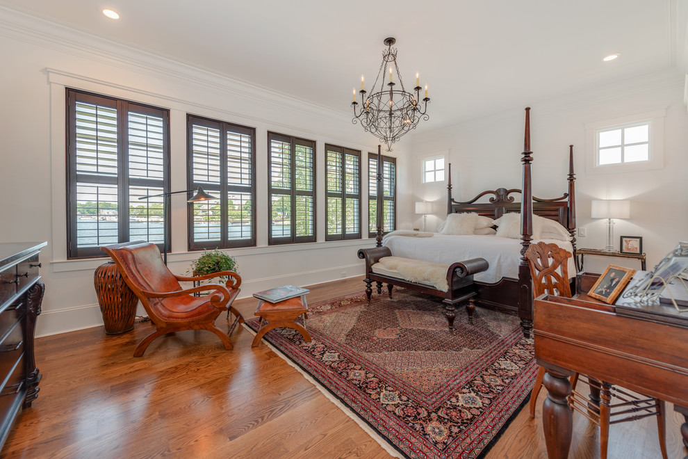 Esempio di una camera da letto country con pareti bianche, pavimento in legno massello medio e pavimento marrone