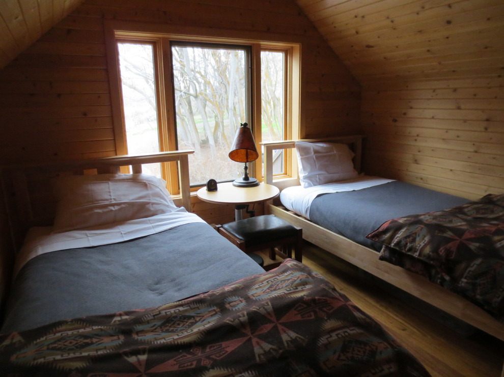 Mid-sized mountain style loft-style medium tone wood floor bedroom photo in Boise