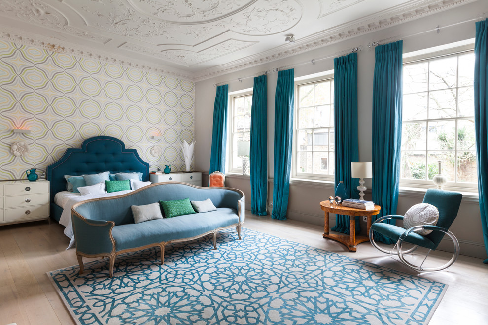 This is an example of a large contemporary master bedroom in London with multi-coloured walls and light hardwood flooring.