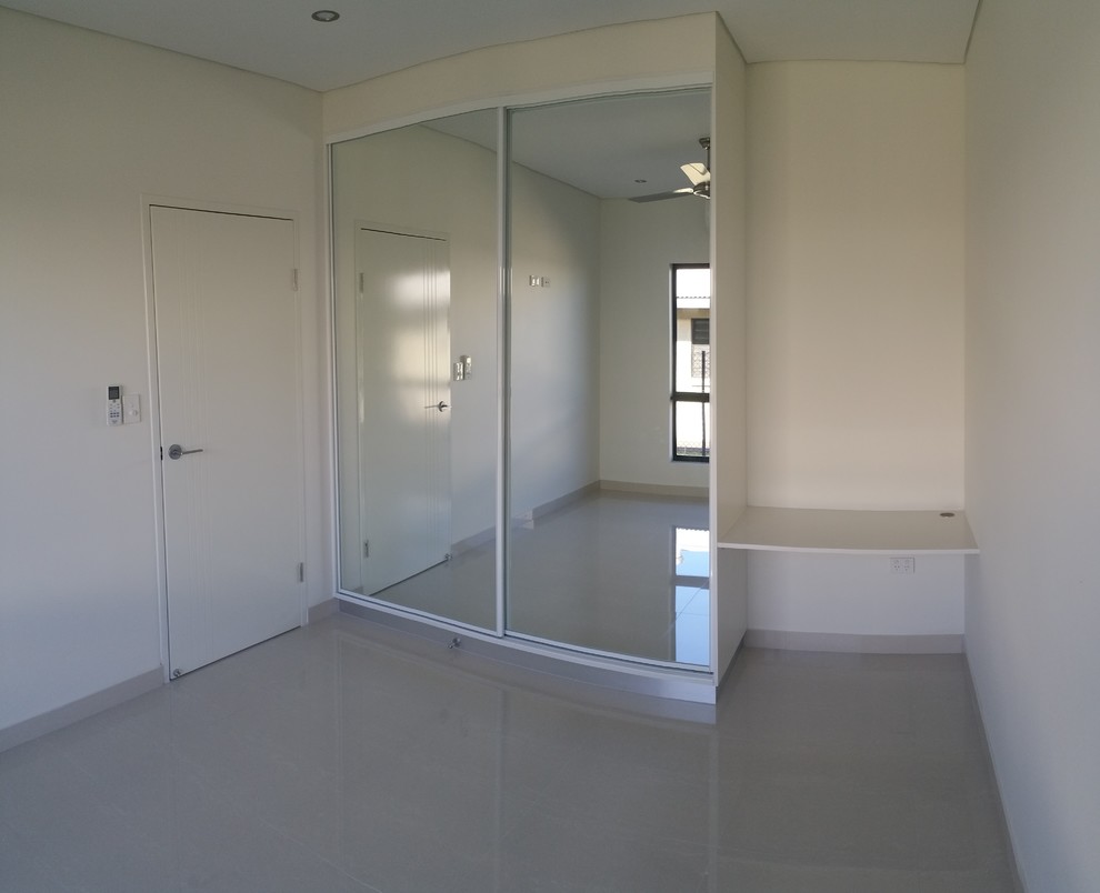 Medium sized modern guest bedroom in Darwin with white walls, porcelain flooring and no fireplace.