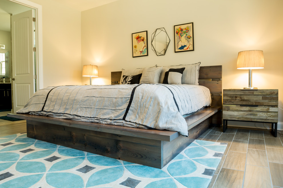 Modelo de dormitorio principal rústico grande sin chimenea con paredes grises, suelo de madera clara y suelo marrón