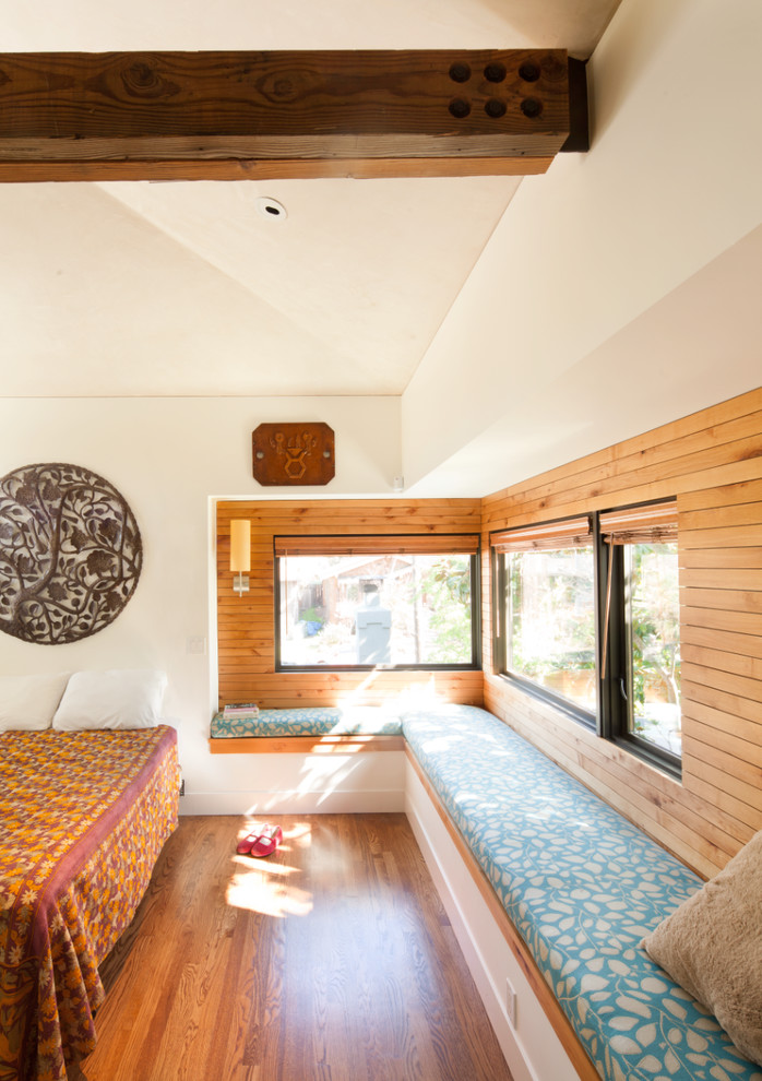 Idéer för funkis sovrum, med vita väggar och mellanmörkt trägolv