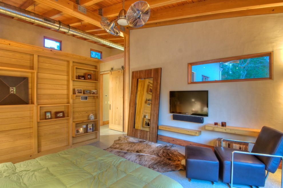 Идея дизайна: хозяйская спальня среднего размера в стиле кантри с бетонным полом, телевизором, бежевыми стенами, серым полом, балками на потолке и стенами из вагонки без камина