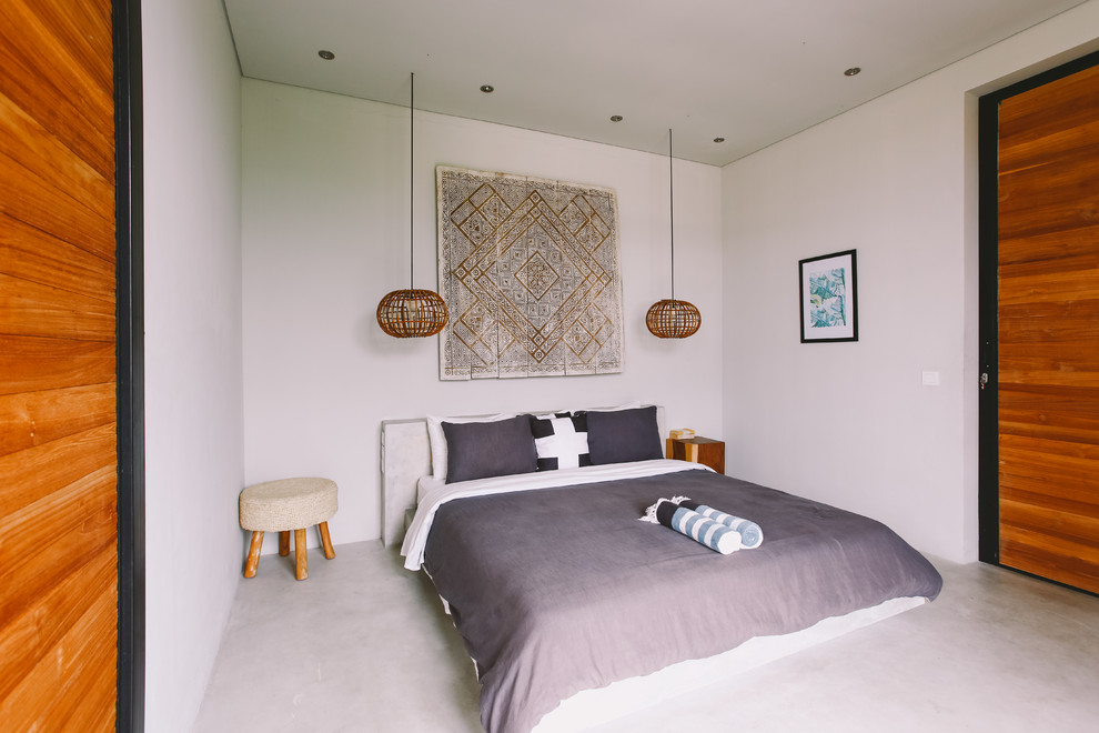 Идея дизайна: спальня в стиле фьюжн с белыми стенами, бетонным полом и серым полом