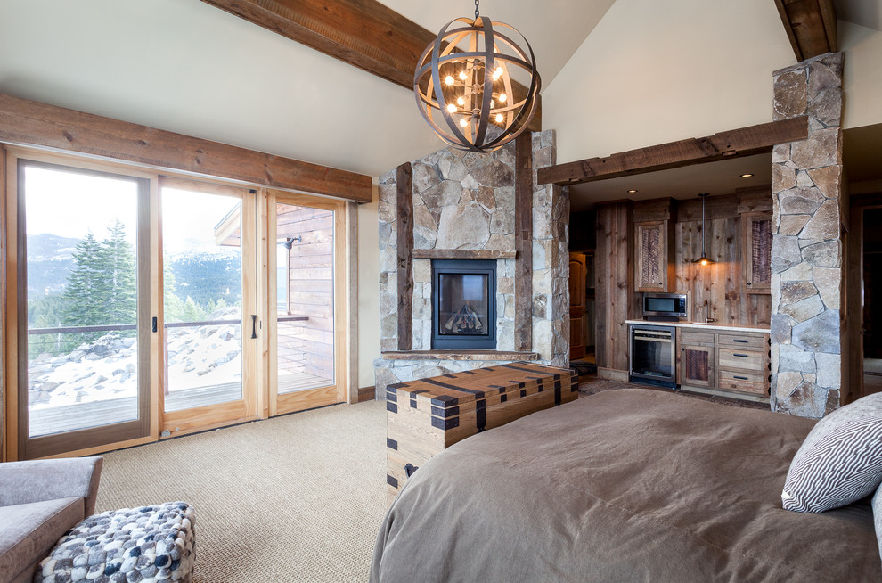 Large mountain style master carpeted bedroom photo in Sacramento with beige walls, a corner fireplace and a stone fireplace
