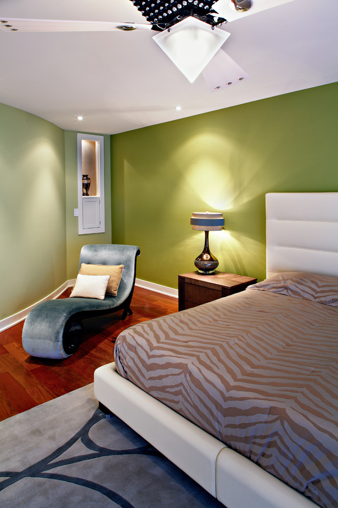 На фото: большая хозяйская спальня в современном стиле с зелеными стенами и темным паркетным полом без камина с