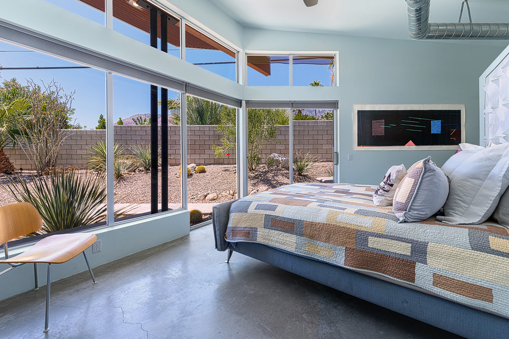 Modern inredning av ett sovrum, med betonggolv och blå väggar